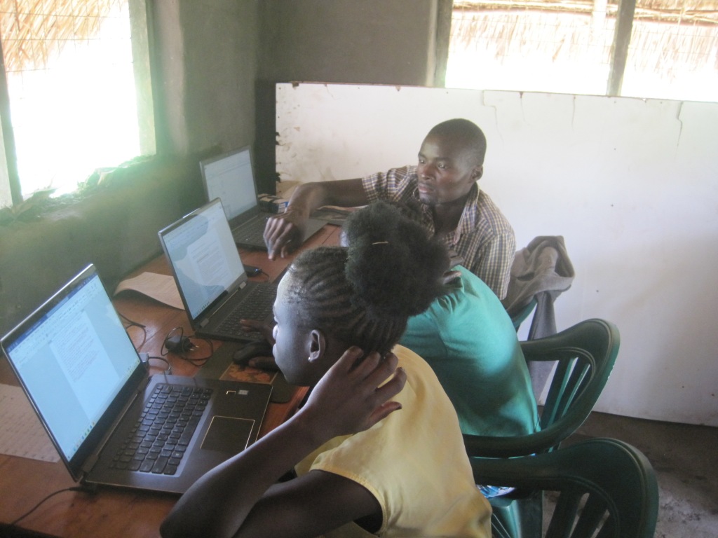 Never (yes, that is her name), Safina, and Baraka working on computer skills practicals in the temporary location while the Mugujai mission center was being expanded.